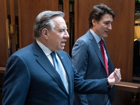 François Legault, in foreground at left, gestures while talking with Justin Trudeau.