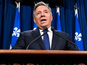 Quebec Premier François Legault stands at a lectern at the National Assembly during a press conference.