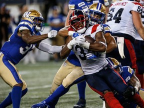 Blue Bombers' Kyrie Wilson (centre back) tackles Montreal Alouettes' William Stanback (31) in Winnipeg on August 24, 2023.