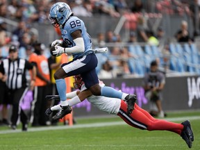 Argonauts wide receiver Cam Phillips (89) jumps with the ball to avoid being tackled by Alouettes defensive back Ciante Evans (4) during first half CFL football action in Toronto on Saturday, Sept. 9, 2023.