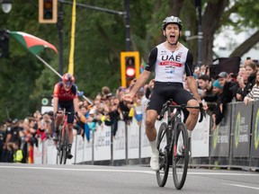 Adam Yates yells with his arms stretched out as he crosses the finish on Parc Ave.
