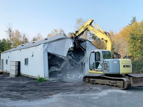 A front loader demolishes a building