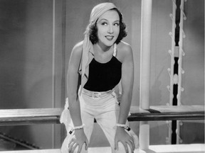 Ethel Merman in a black tank top and wide pants, with a white bandana on her head.
