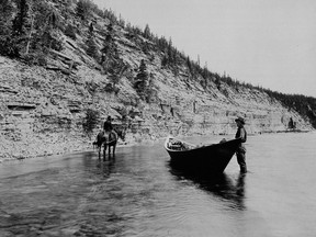 Black and white photo of a person getting out of a boat next to an island