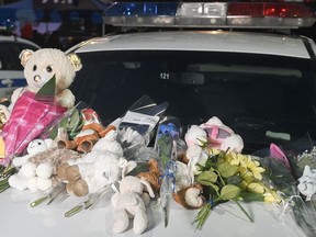 A makeshift memorial is shown on a police car in Laval on Wednesday, Feb. 8, 2023, near the scene where a city bus crashed into a daycare centre leaving two children dead.