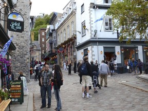 People stroll through old Quebec City on Aug. 13, 2013. Quebec's illegal tourist accommodation law is in effect, with hefty fines of up to $100,000 for short-term rental platforms listing properties without a proper government certificate.