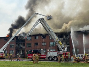 Montreal firefighters battle a four-alarm blaze at a residential building in Dorval on Saturday afternoon at the corner of Dawson Ave. and Garden Crescent around 1 p.m.