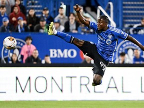 CF Montréal's Kwadwo Opoku, wearing a blue shirt and black shorts, jumps to kick the ball Wednesday night.