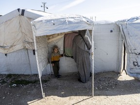 a woman and a child are standing in a white tent