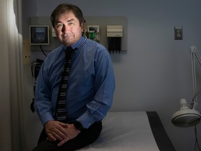 Mark Roper sits on a hospital bed, with only his face lit up