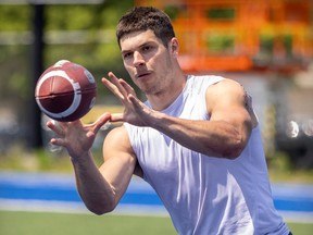Alouettes receiver Cole Spieker is seen in a sleeveless shirt extending his arms and opening his hands to catch the football during training camp in May.