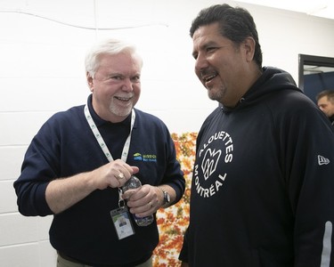 Welcome Hall Mission president and CEO Sam Watts and Montreal Alouettes quarterbacks coach Anthony Calvillo smile together as they prepare to serve Thanksgiving dinner.
