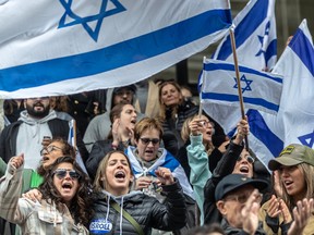A crowd holds up Israeli flags at a rally