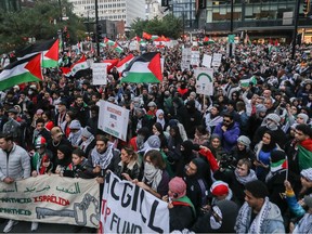 People holding up Palestinian flags and signs shouting