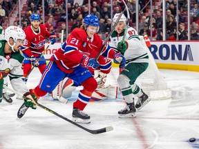 Canadiens defenceman Kaiden Guhle skates between Wild's Marcus Johansson, left, and Kirill Kiprizov to chase a loose puck Tuesday night.