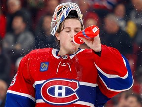 Sam Montembeault drinks from a water bottle during a break in play