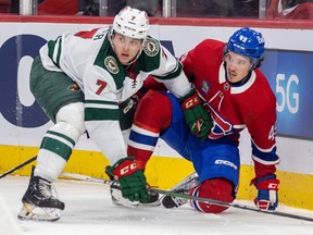 Canadiens' Rafael Harvey-Pinard and Minnesota Wild's Brock Faber on the ice looking off-camera