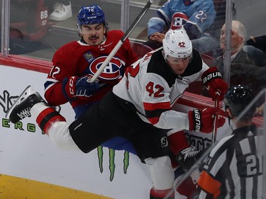 Montreal Canadiens' Arber Xhekaj (72) is pinned along the boards by New Jersey Devils' Curtis Lazar