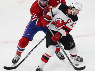 Montreal Canadiens' Justin Barron (52) battles for the puck with New Jersey Devils' Nico Hischier