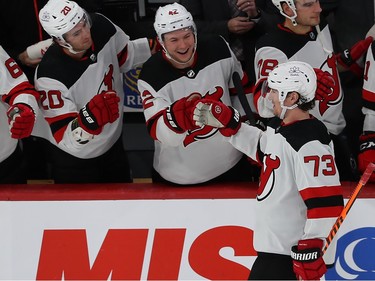 Devils' Tyler Toffoli (73) skates to his bench where teammates are smiling