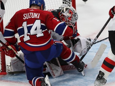 New Jersey Devils goaltender Vitek Vanecek and Montreal Canadiens' Nick Suzuki in the crease