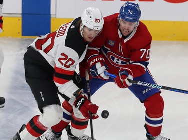 Montreal Canadiens' Tanner Pearson (70) and New Jersey Devils' Michael McLeod (20) battle for a loose puck