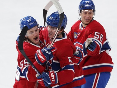 Three Canadiens players embrace each other after a goal