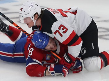 Tyler Toffoli lies down on the ice atop a grimacing Mike Matheson