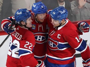 Canadiens' Mike Matheson is hugged by teammates Cole Caufield, left, and Nick Suzuki (after scoring a late second-period goal Thursday night.