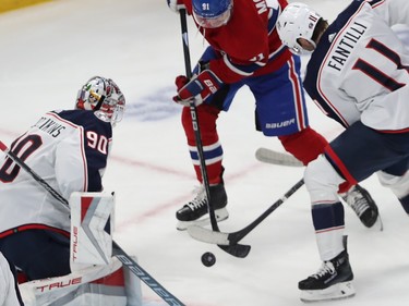 Montreal Canadiens' Sean Monahan (91) battles for the puck with Columbus Blue Jackets' Adam Fantilli (11), in front of goaltender Elvis Merzlikins