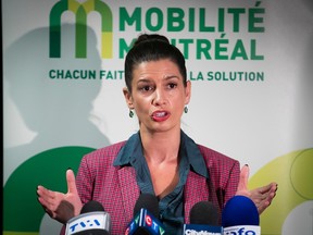 Geneviève Guilbault stands at microphones in front of the Mobilité Montréal logo