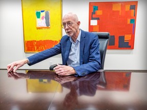 Concordia University President Graham Carr is pictured in a room with paintings on the wall.