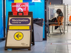 A woman sits waiting at a COVID vaccination centre in the Montreal borough of Lachine.