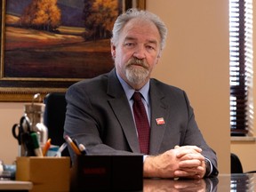 John McMahon sits at a wooden desk in an office