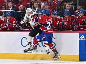 Canadiens forward Juraj Slafkovsky plants Blackhawks' Jason Dickinson into the boards in front of the Montreal bench last week.