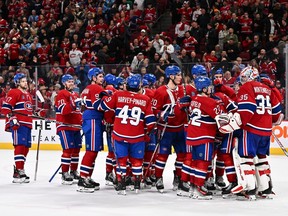 Canadiens players gather on the ice to congratulate goaltender Samuel Montembeault after beating the Blackhawks 3-2 on Saturday night.