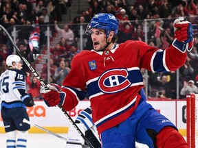 Canadiens' Sean Monahan is seen raising his gloves and stick in the air as he lets out a triumphant roar after scoring a late second-period goal Saturday night against the Jets at the Bell Centre.