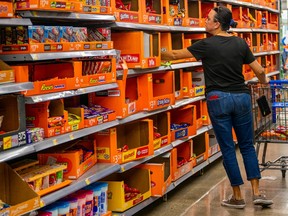 A shopper chooses halloween candy from shelves at Walmart in Austin, Texas.
