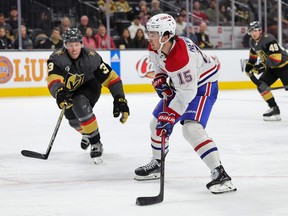 A hockey player skates with the puck past his opponent