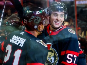 Senators centre Shane Pinto, right, celebrates a goal with teammate Mathieu Joseph and an ad for Bet99 can clearly be seen on the side of Joseph's helmet.
