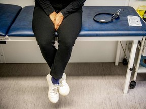Patient sitting on an examination table in a doctor's office.