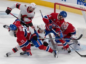 Canadiens' Cayden Primeau makes a save against Senators' Ridly Greig as defencemen Kaiden Guhle and William Trudeau work to clear the front of the net during pre-season action at the Bell Centre last month.