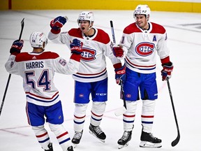 Three Montreal Canadiens players celebrate after a goal
