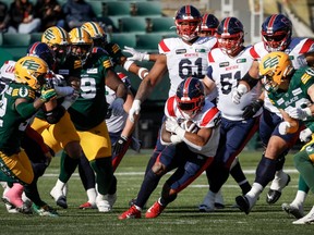 Alouettes running back Walter Fletcher, centre, moves the ball past Edmonton Elks players in Edmonton on Saturday, Oct. 14, 2023.