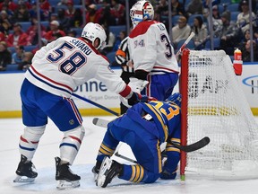 Canadiens defenceman David Savard is seen pushing Sabres winger at the side of the Montreal net as Habs goalie Jake Allen watches.