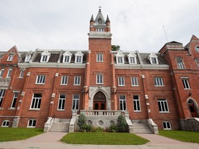 A red brick university building is seen outdoors during the summer