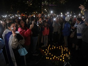 People hold up their phones during a candlelight vigil Tuesday, Oct. 10, at Dorchester Square in Montreal in support of Israel.