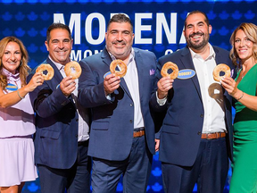 Five people — three men in blazers flanked by two women — hold up bagels on the set of Family Feud Canada