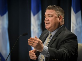 Shawn Dulude gestures sitting at a news conference