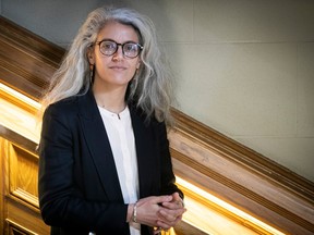 Montreal anti-racism commissioner Bochra Manaï stands on a staircase looking at the camera.